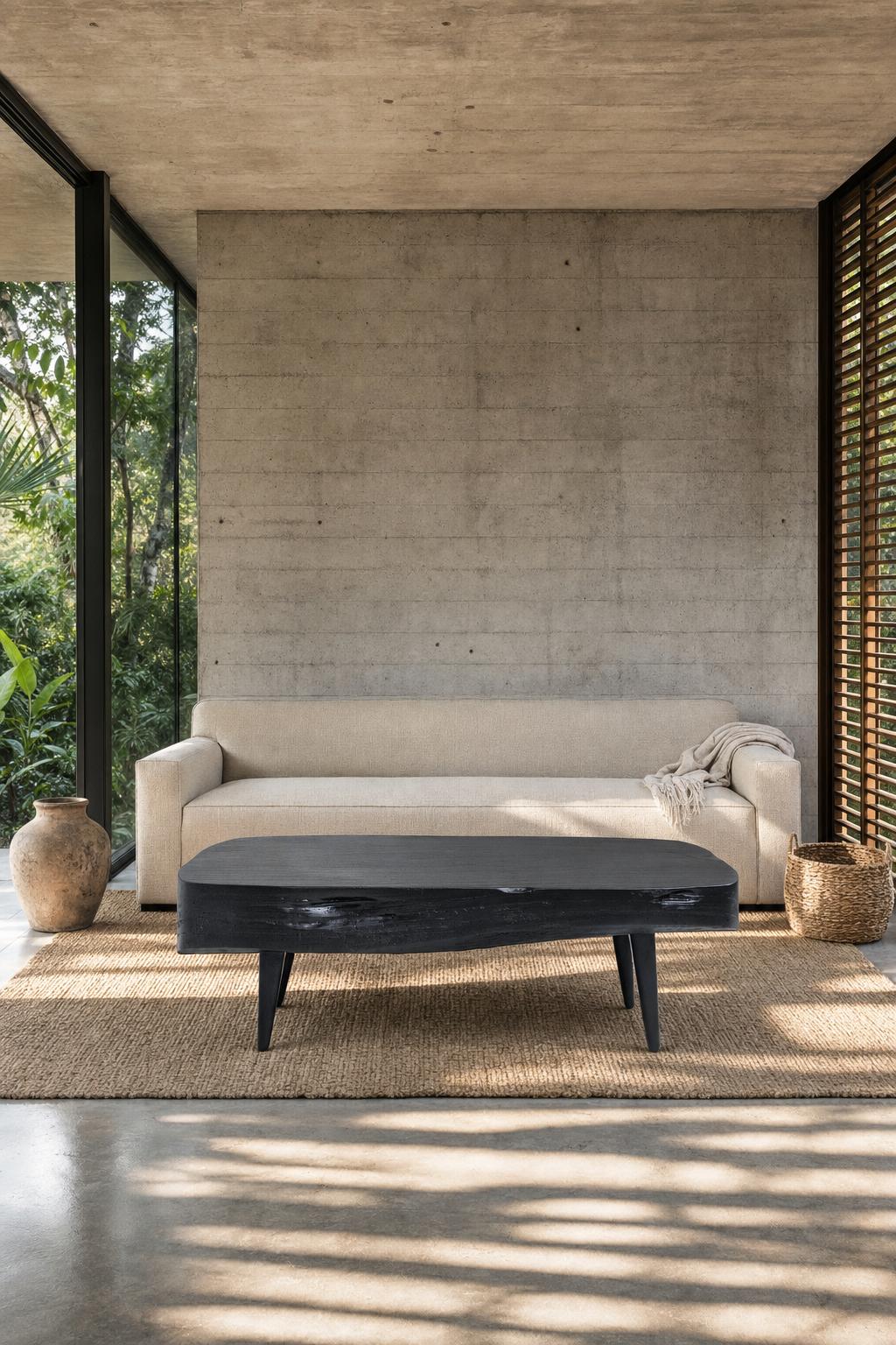 Staged visualisation — Sabana Brasa in a concrete living room, the torched black slab seen straight on in front of a linen sofa