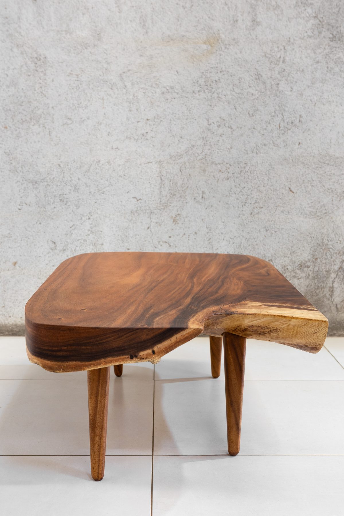Sabana I seen from three-quarters, showing the wave in the live edge and the splayed turned legs