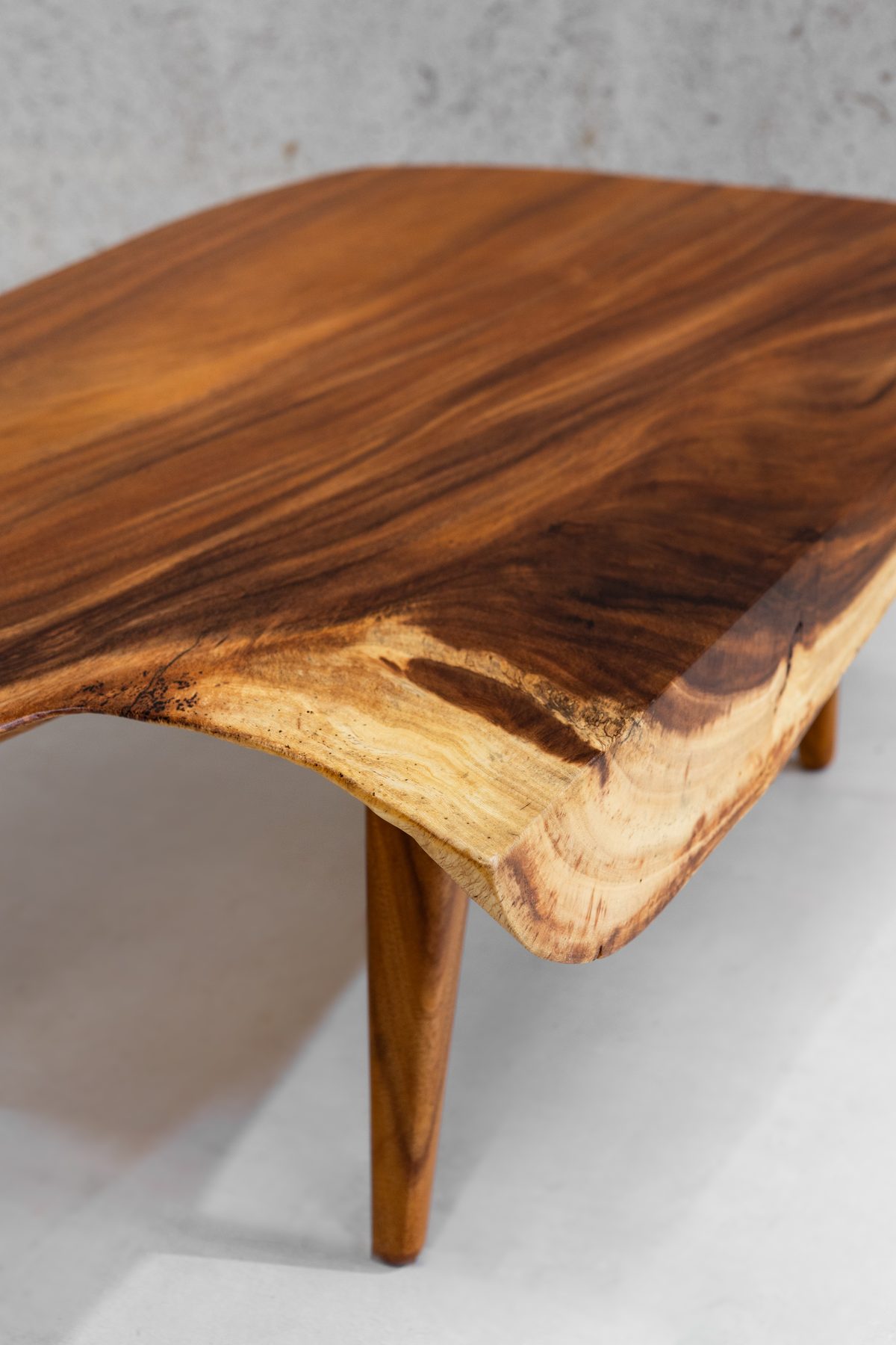 Detail of the Sabana I top — Guanacaste grain running the length of the slab into the pale sapwood edge