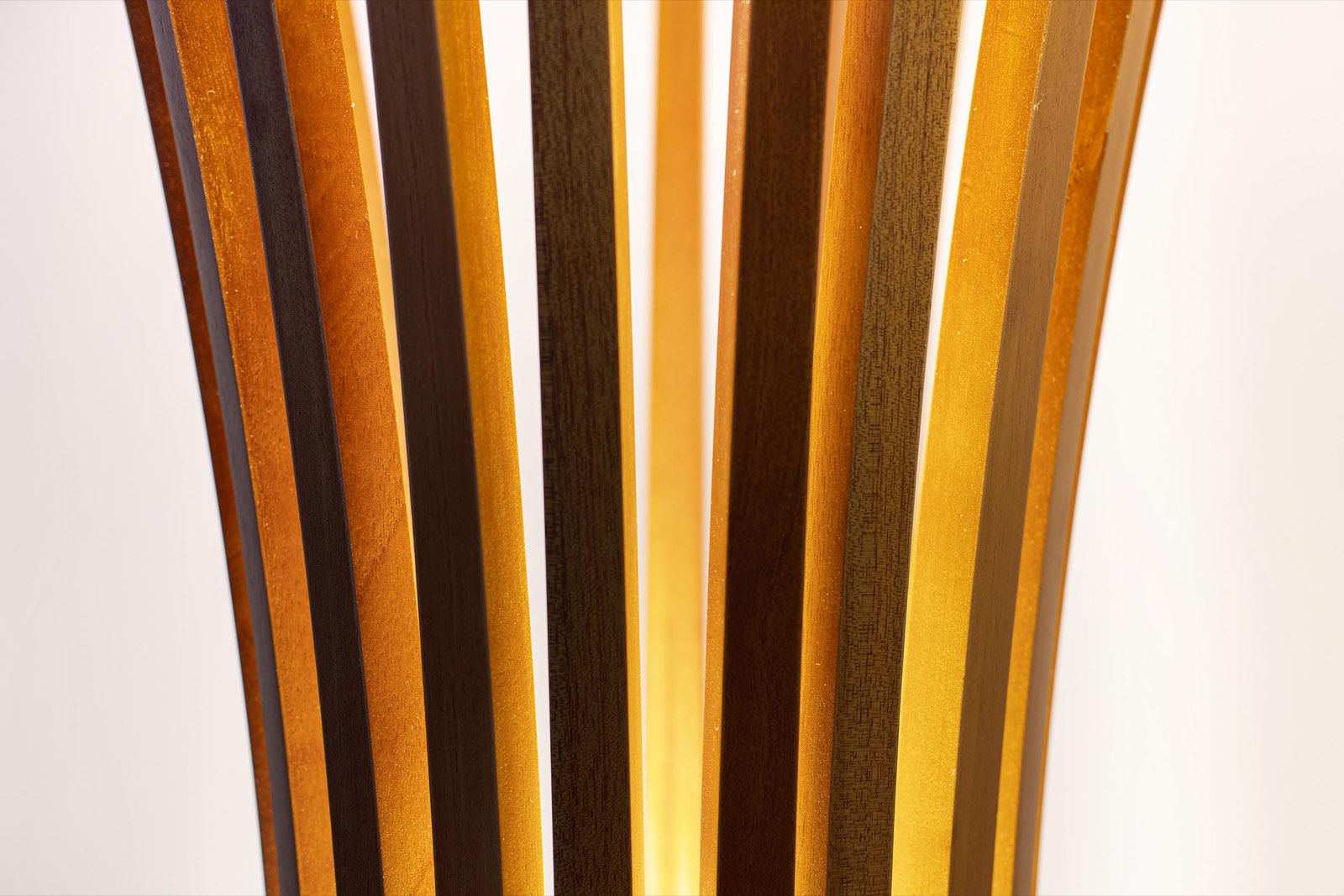 Close detail of the cedar ribs of the Glow of Grace floor lamp with warm light passing between them