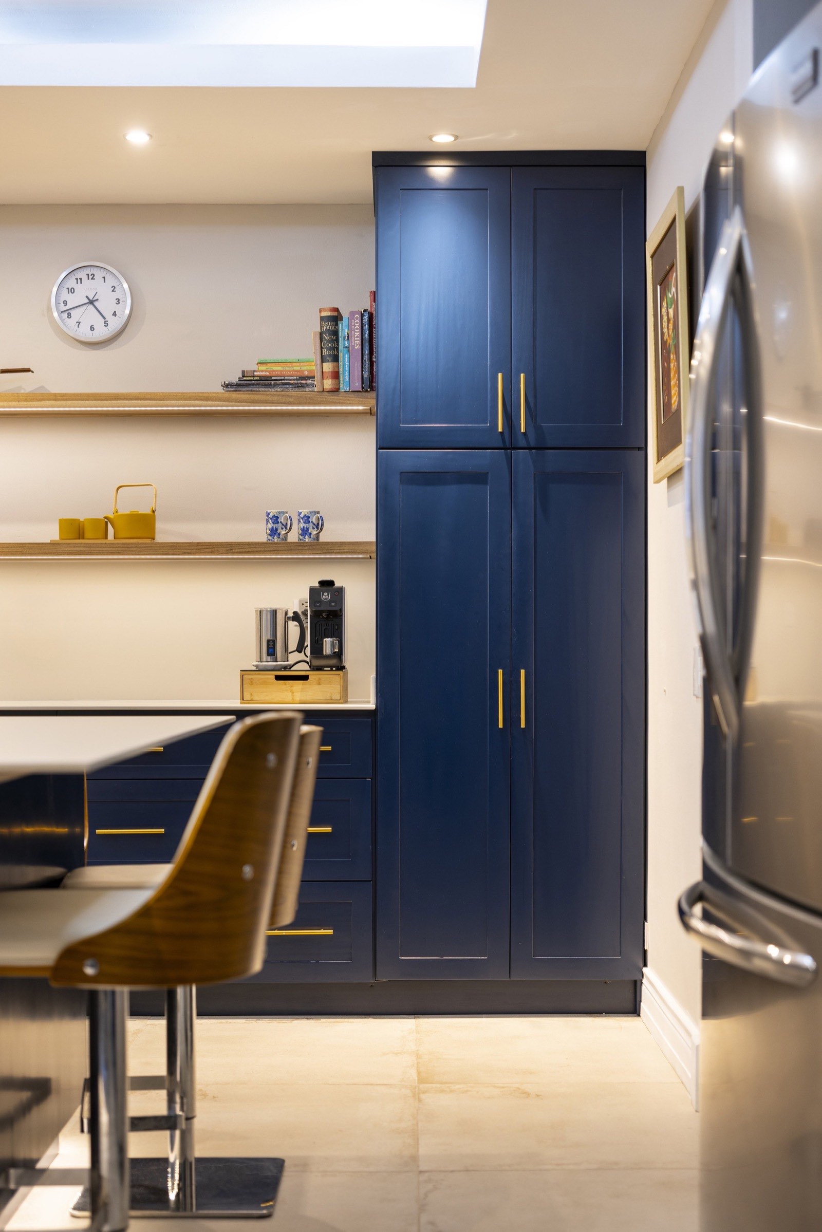 Floor-to-ceiling navy cabinetry with Laurel floating shelves in the Jacamarca kitchen