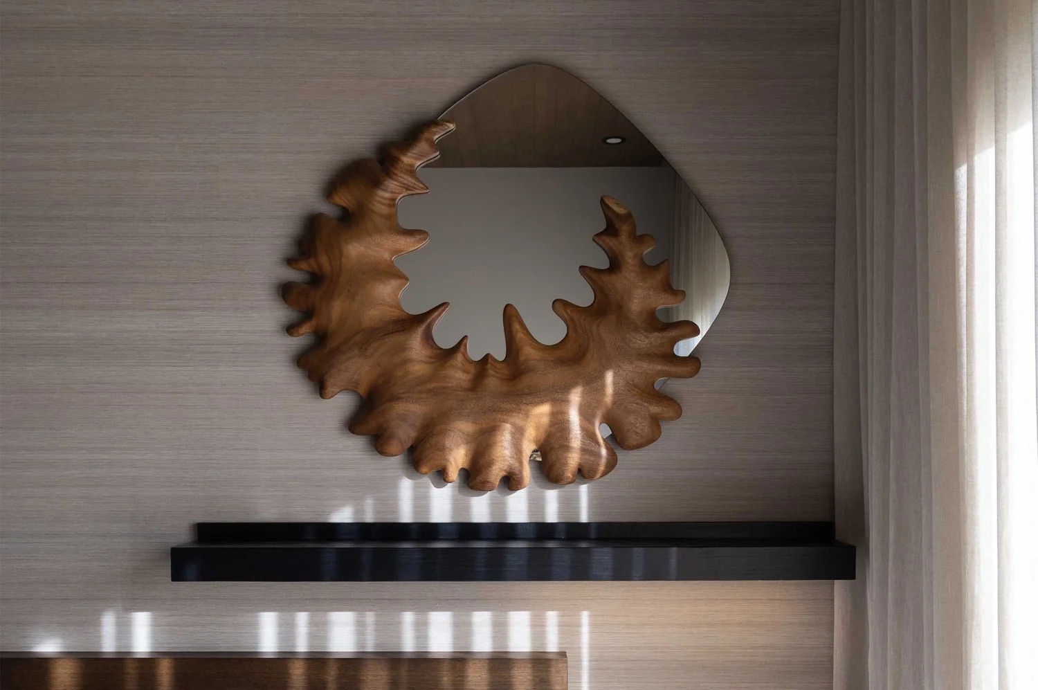 Coral Mirror mounted above a console in a residential interior, seen straight on