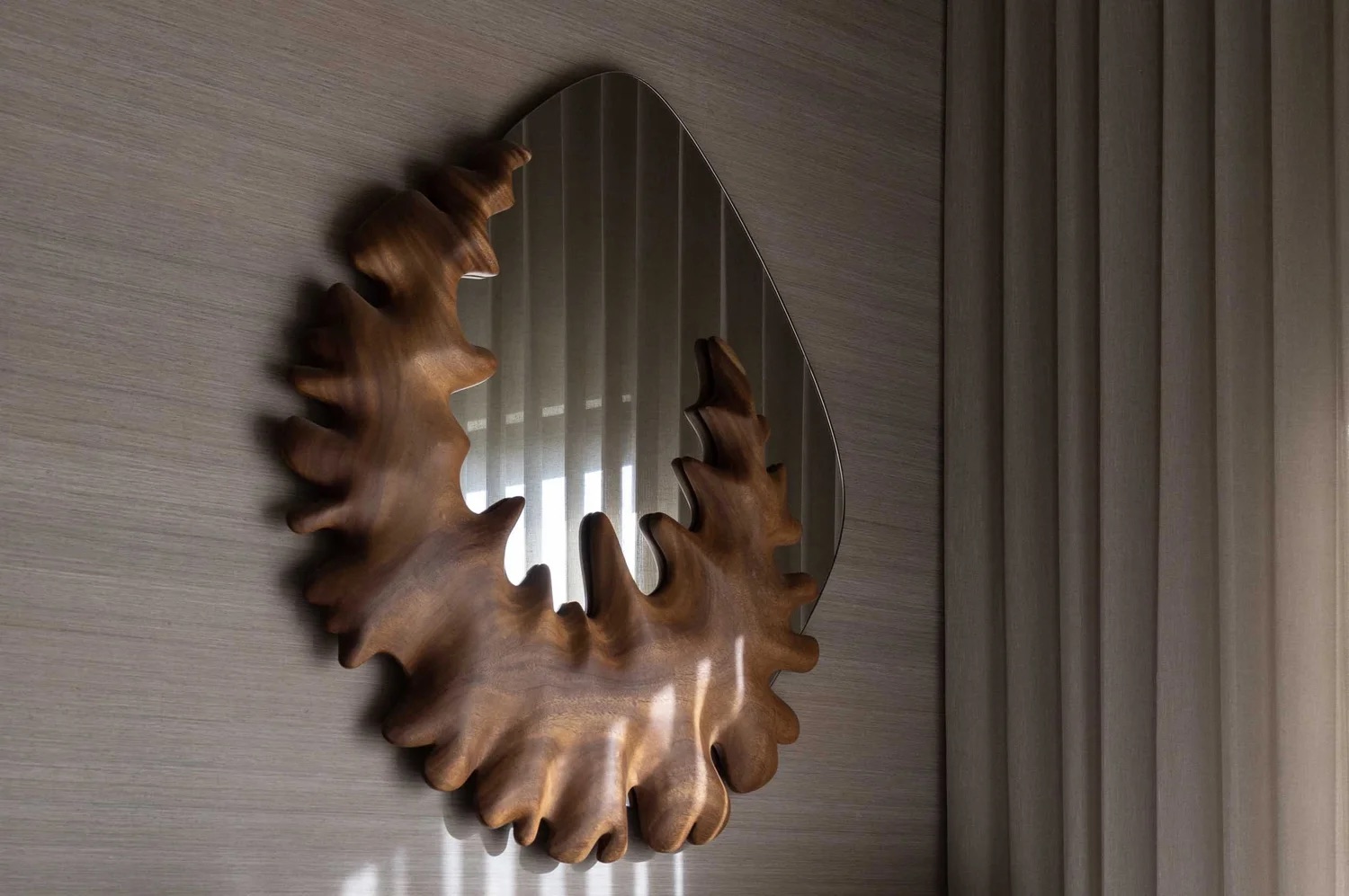 Coral Mirror at an angle in a residential interior beside sheer curtains, catching afternoon light