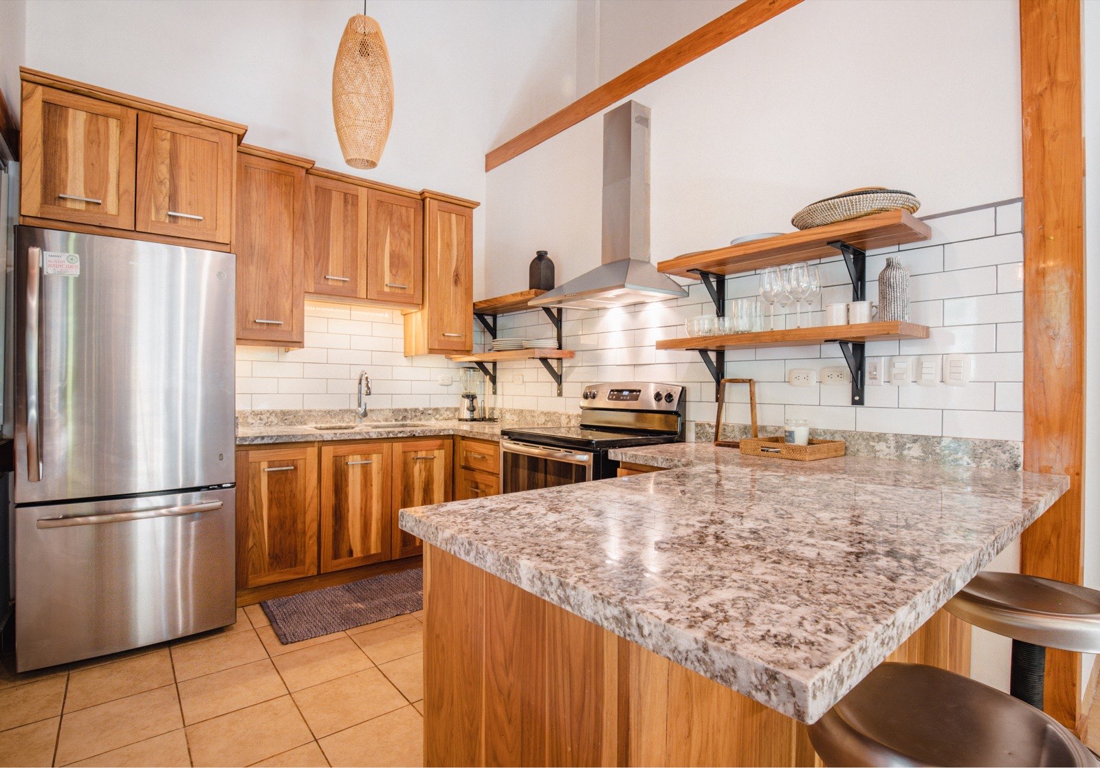 Granite peninsula and open Laurel shelving with a subway-tile backsplash
