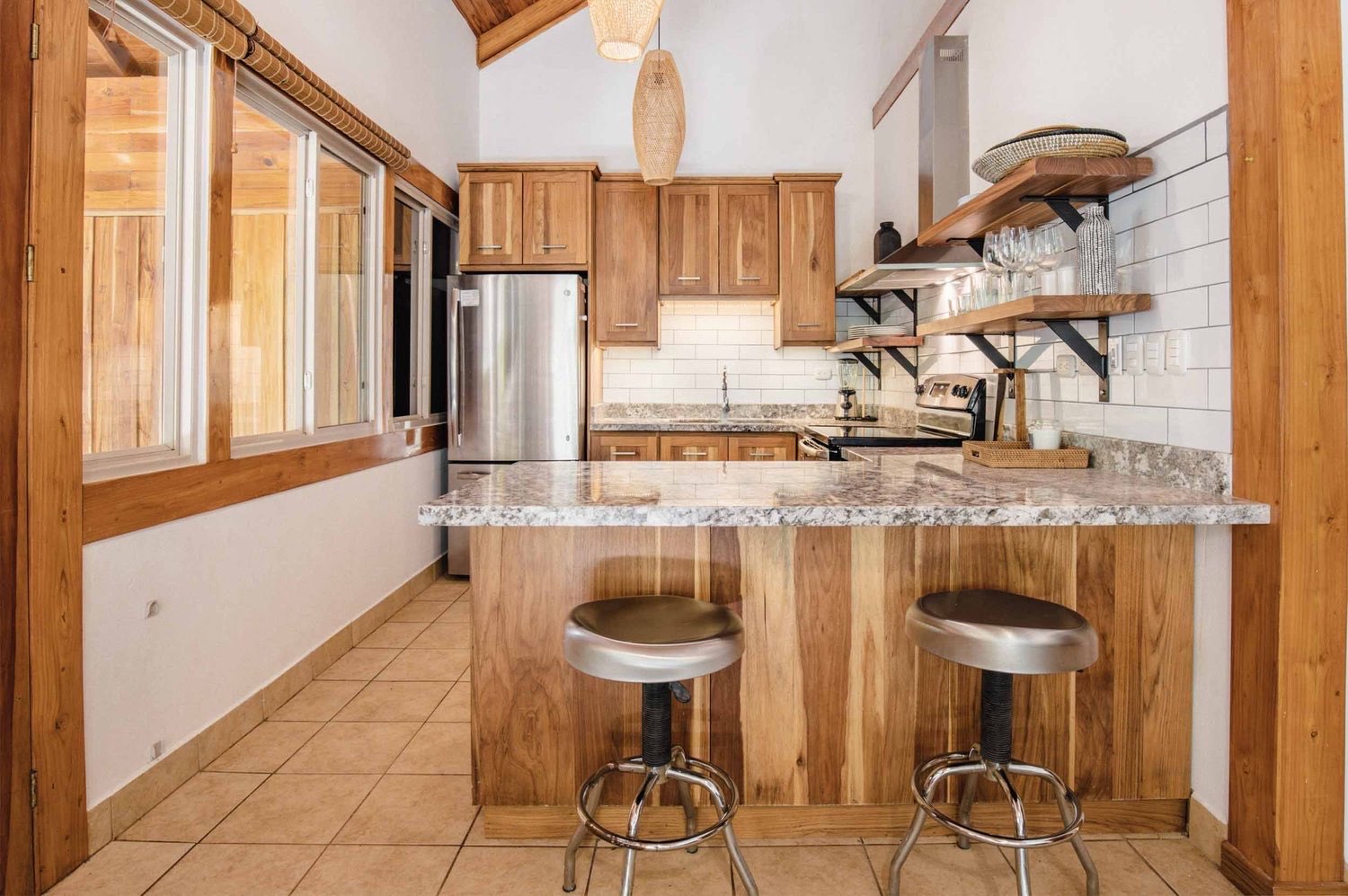 The Playa Guiones 506 kitchen seen across the granite peninsula toward the range and shelving