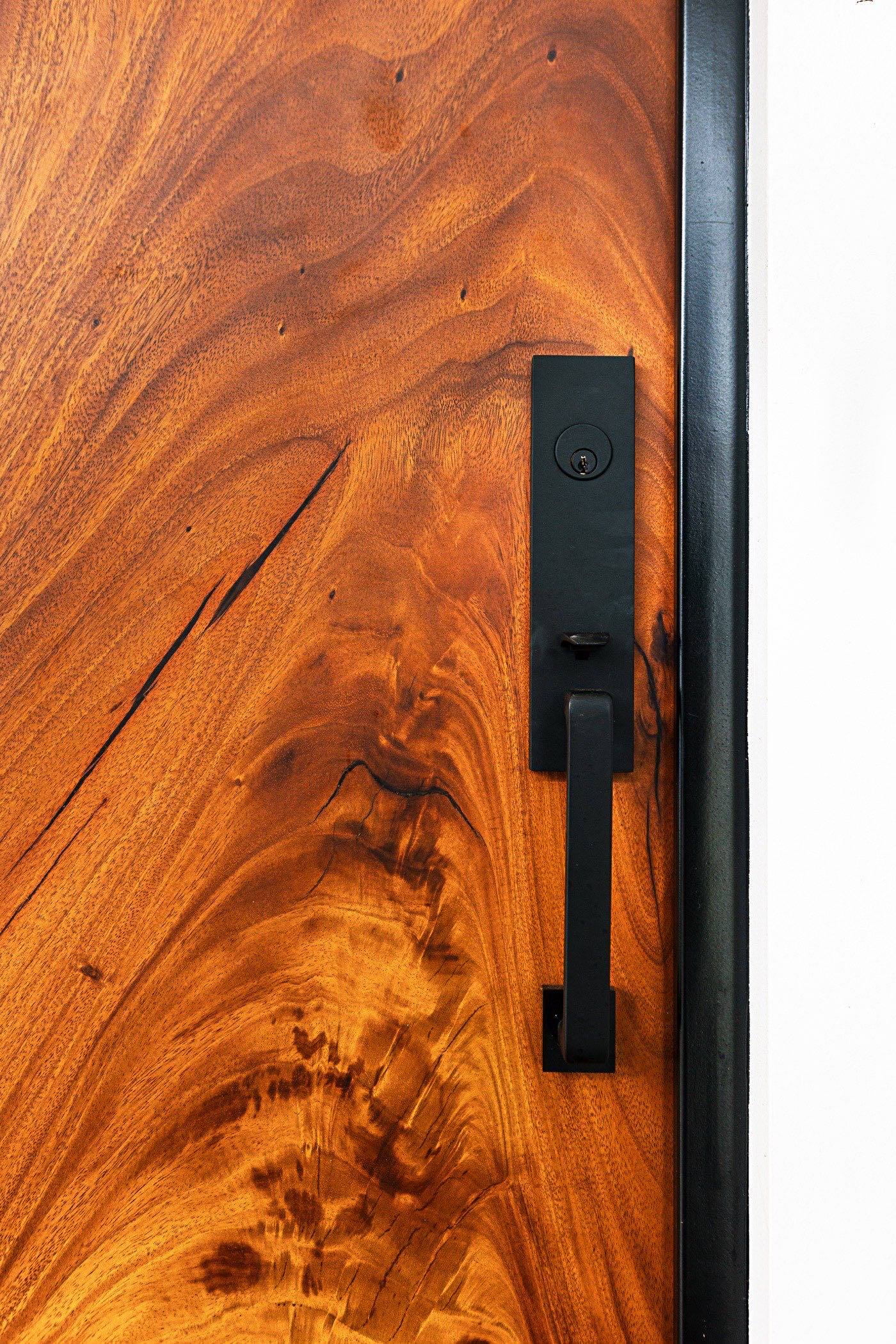 Matte black hardware set into the solid Guanacaste of the Reventazón door