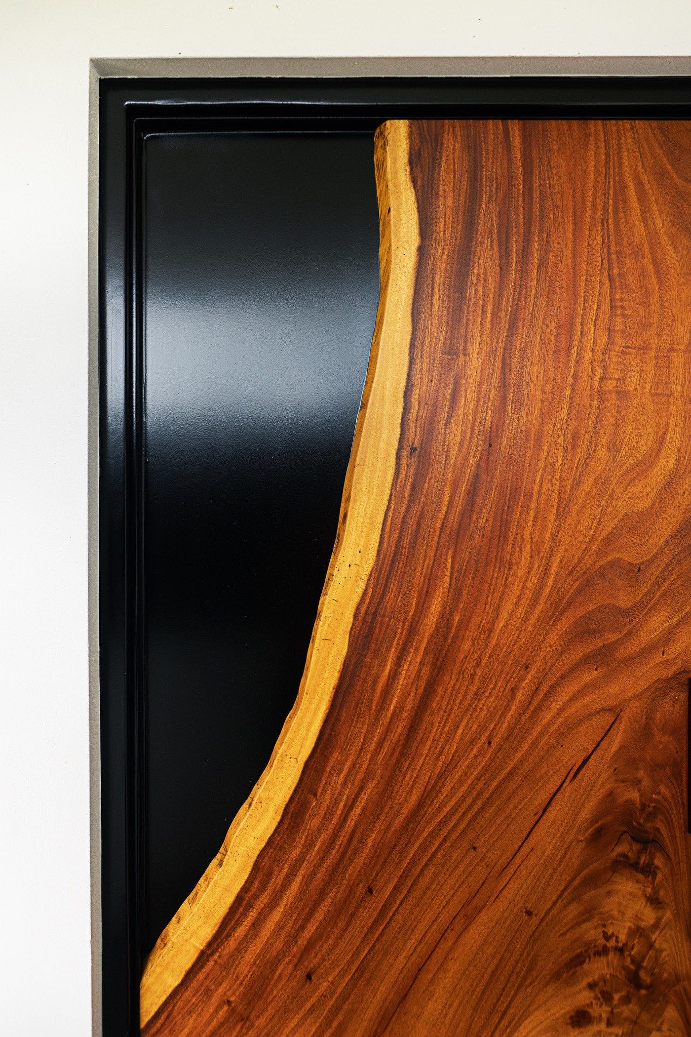 Detail of the Sarapiquí door where the curved live edge meets the black steel infill