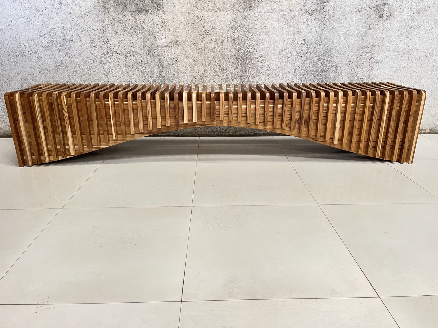 Rib Bench — a long, gently arched bench built from solid Guanacaste slats